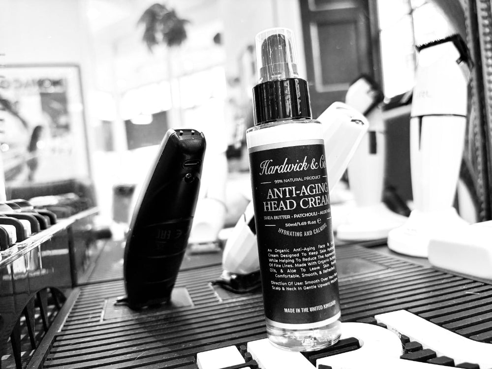 Bottle of Hardwick & Co anti-aging head cream on a counter with blurred background