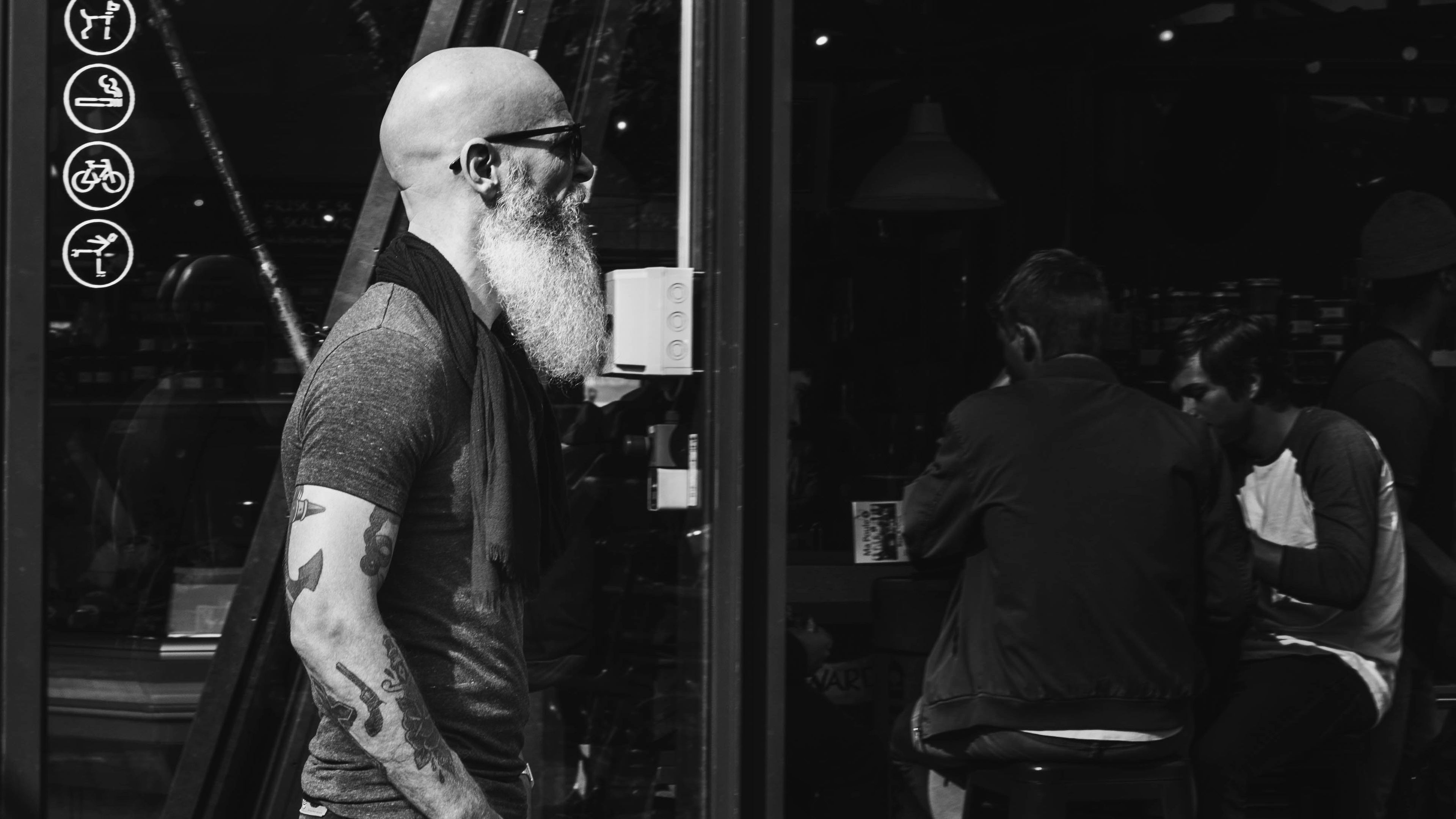 Man with a beard and tattoos standing in a bar setting